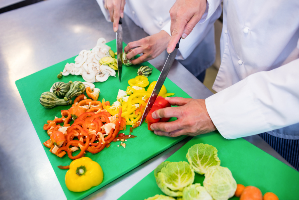 Close up of chefs chopping vegetables